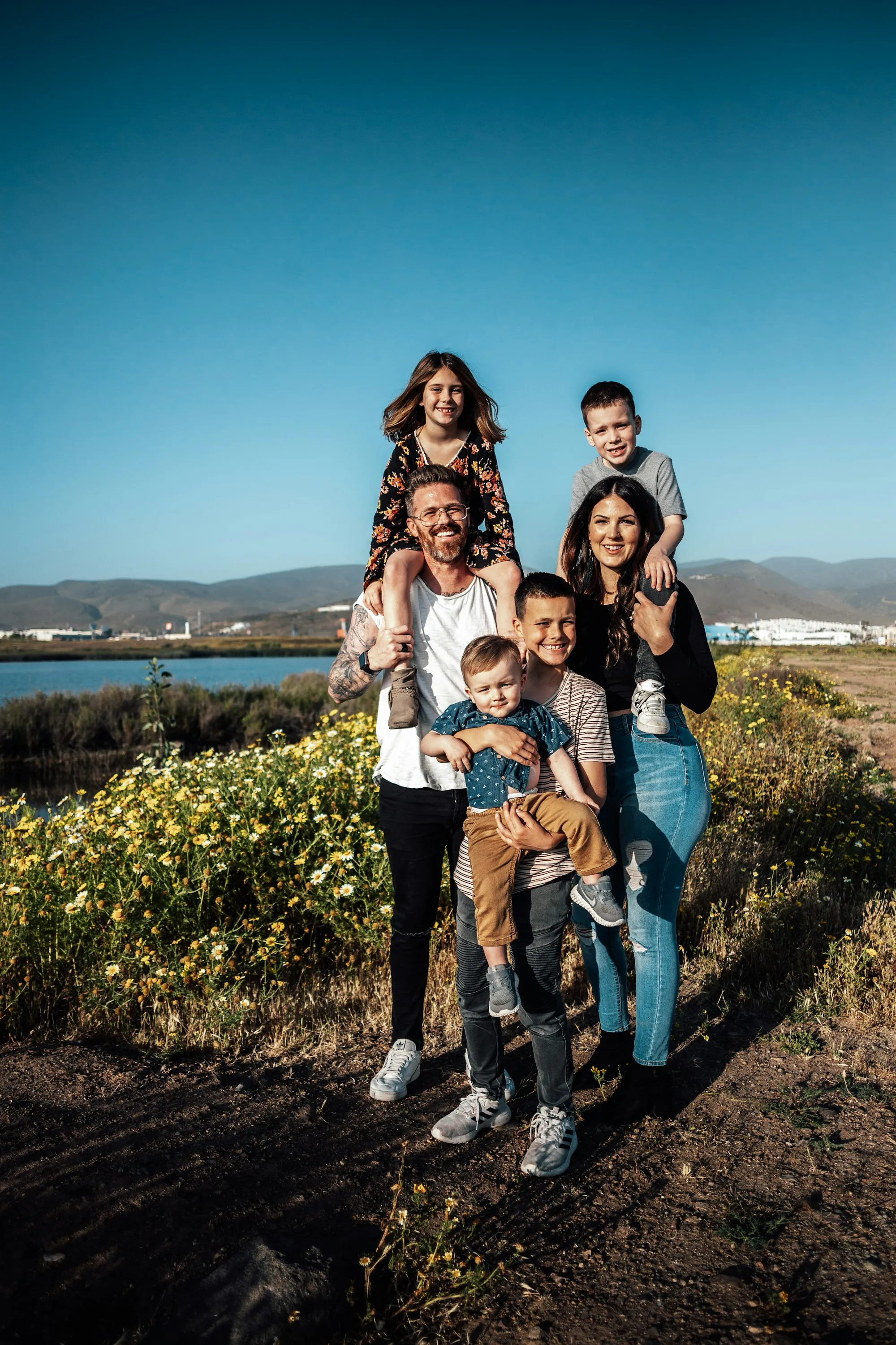 Parents and three children posing by the water