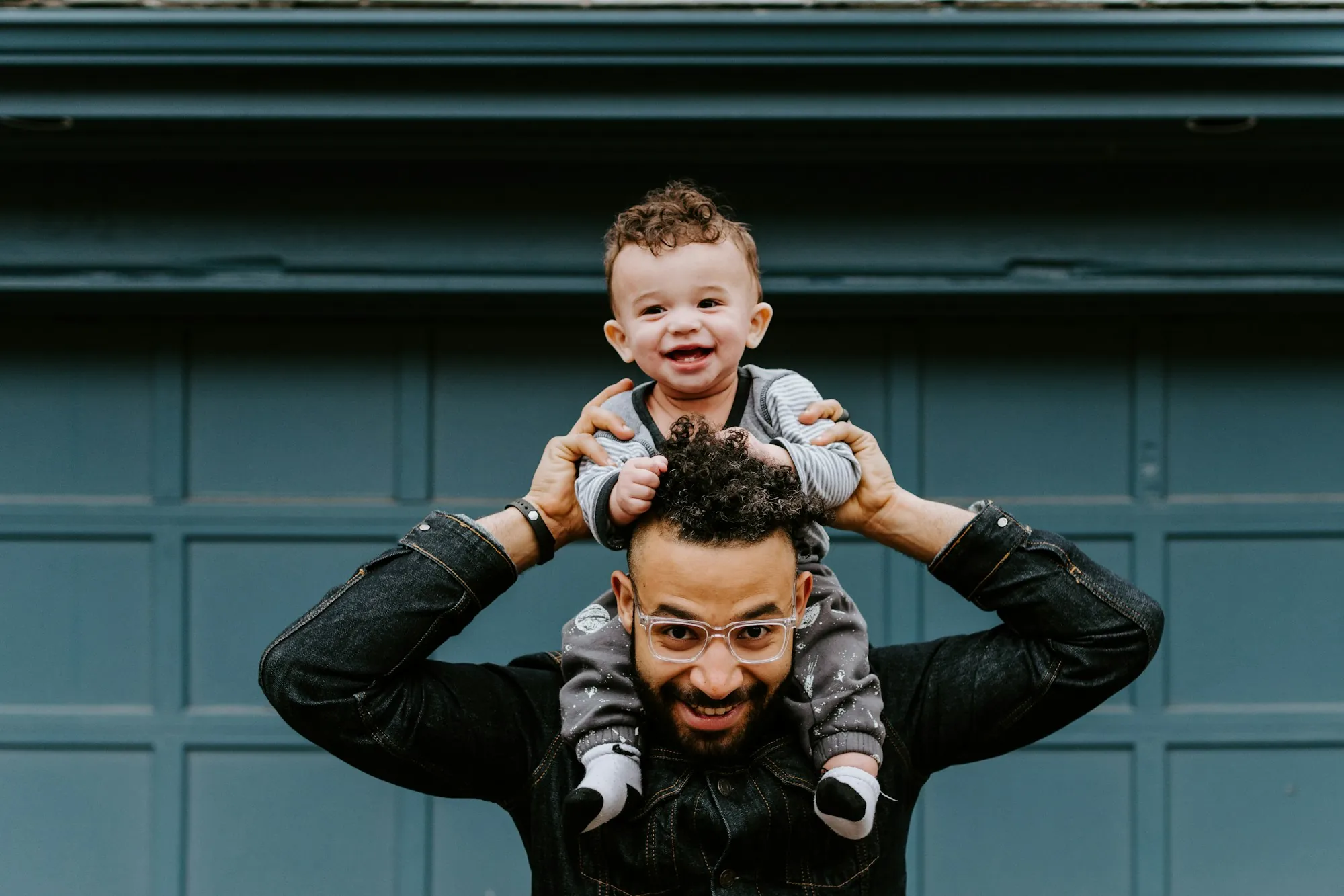 Smiling father with his baby sitting on his shoulders